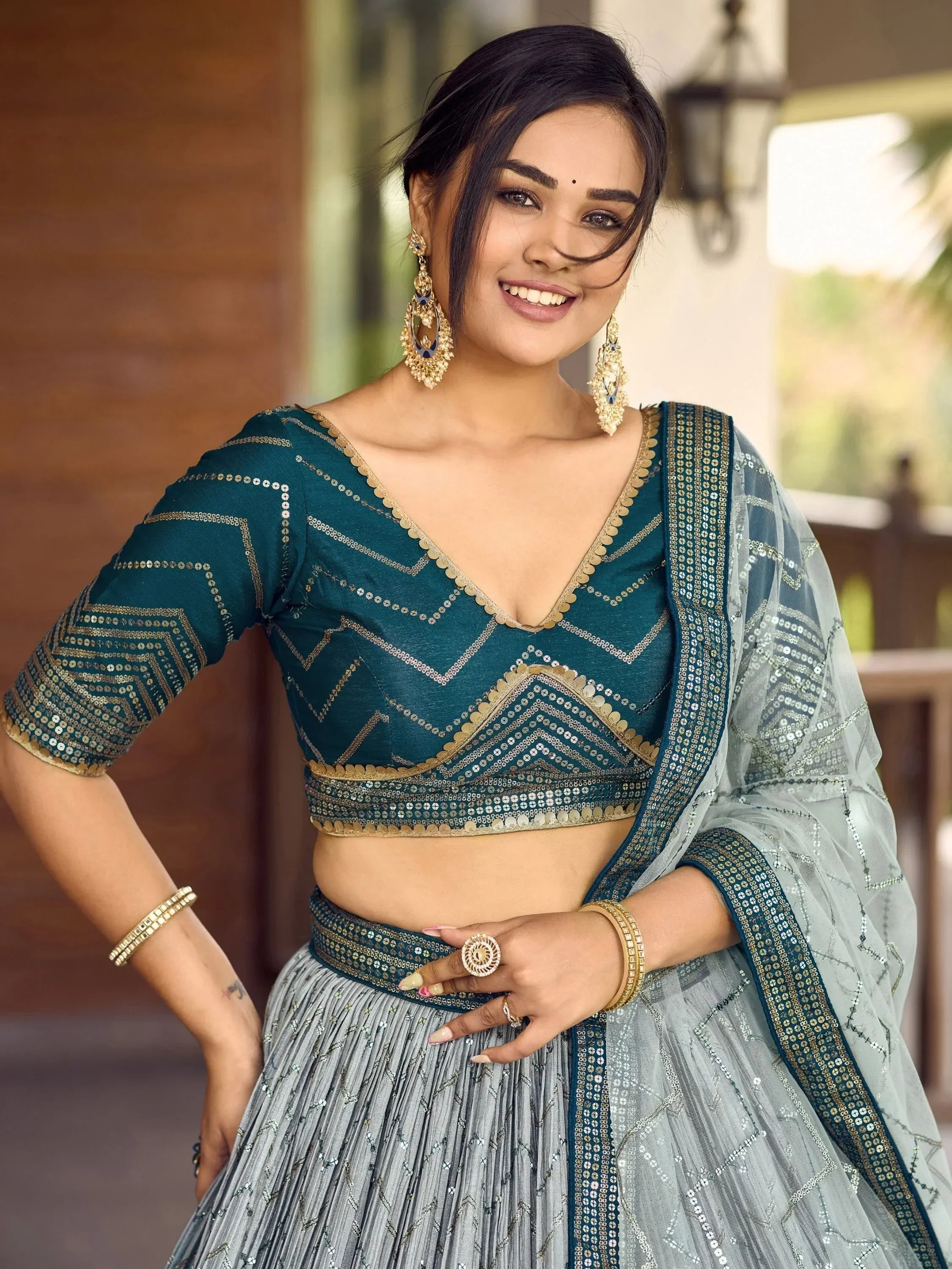 Teal and silver designer lehenga choli with mirror work, perfect for Indian ethnic wear occasions.
