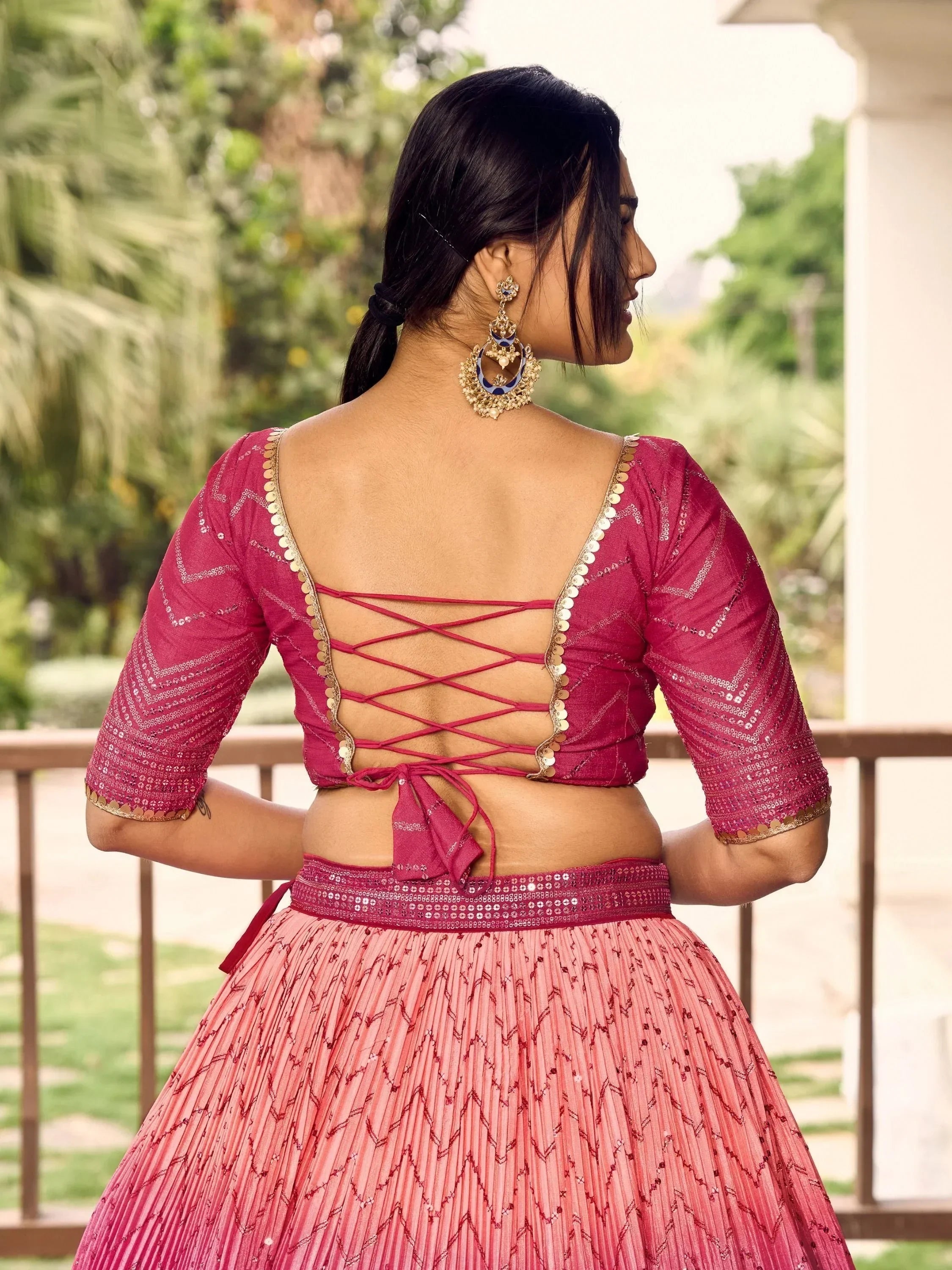Pink designer lehenga choli with back crisscross tie, gold trim, and sequin detailing, perfect for Indian ethnic wear.