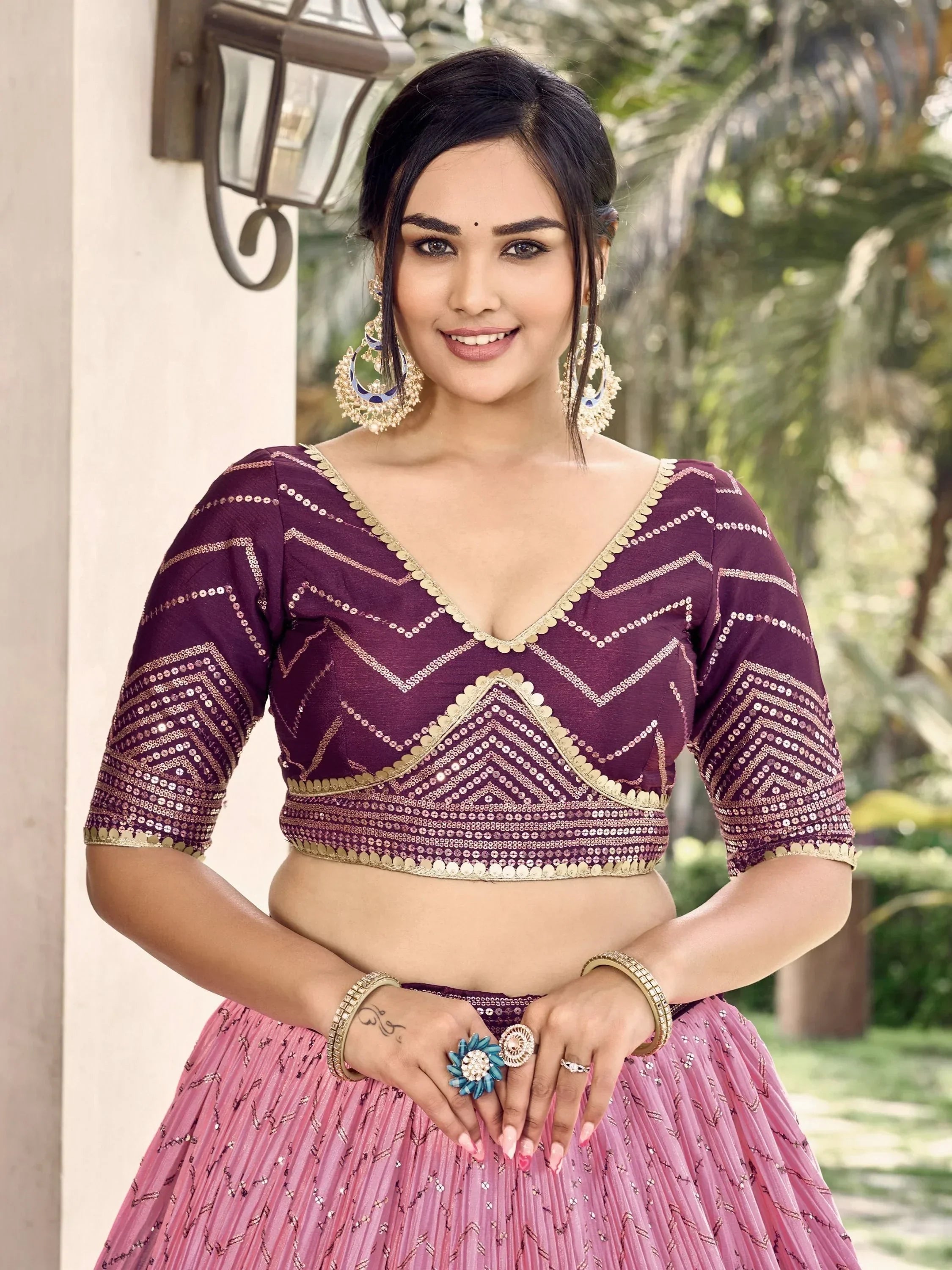 Woman in purple and pink sequined lehenga choli with gold embroidery, perfect for Indian ethnic wear events