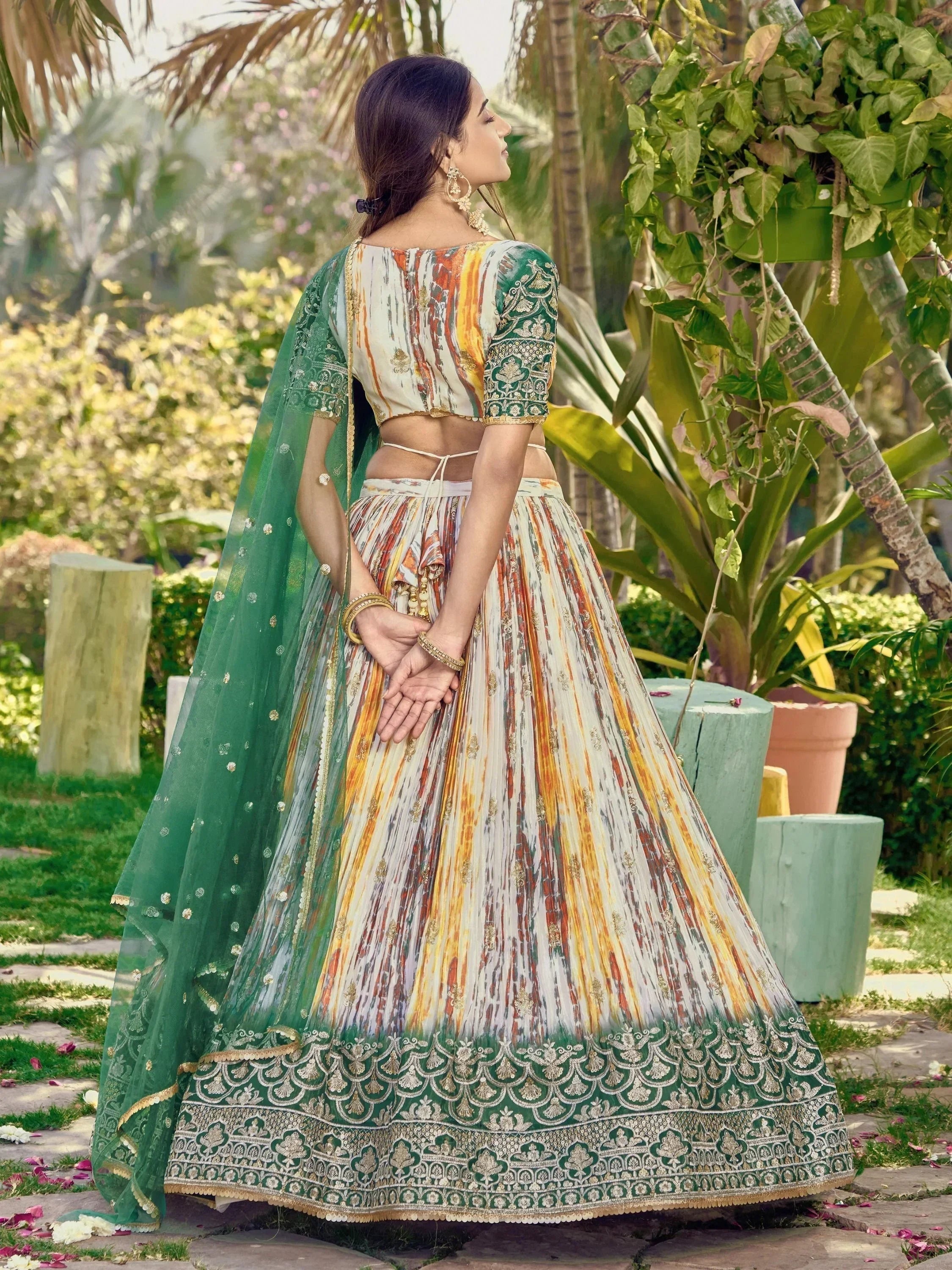 Woman in colorful printed lehenga choli with green dupatta, ethnic Indian wear for weddings or festivals
