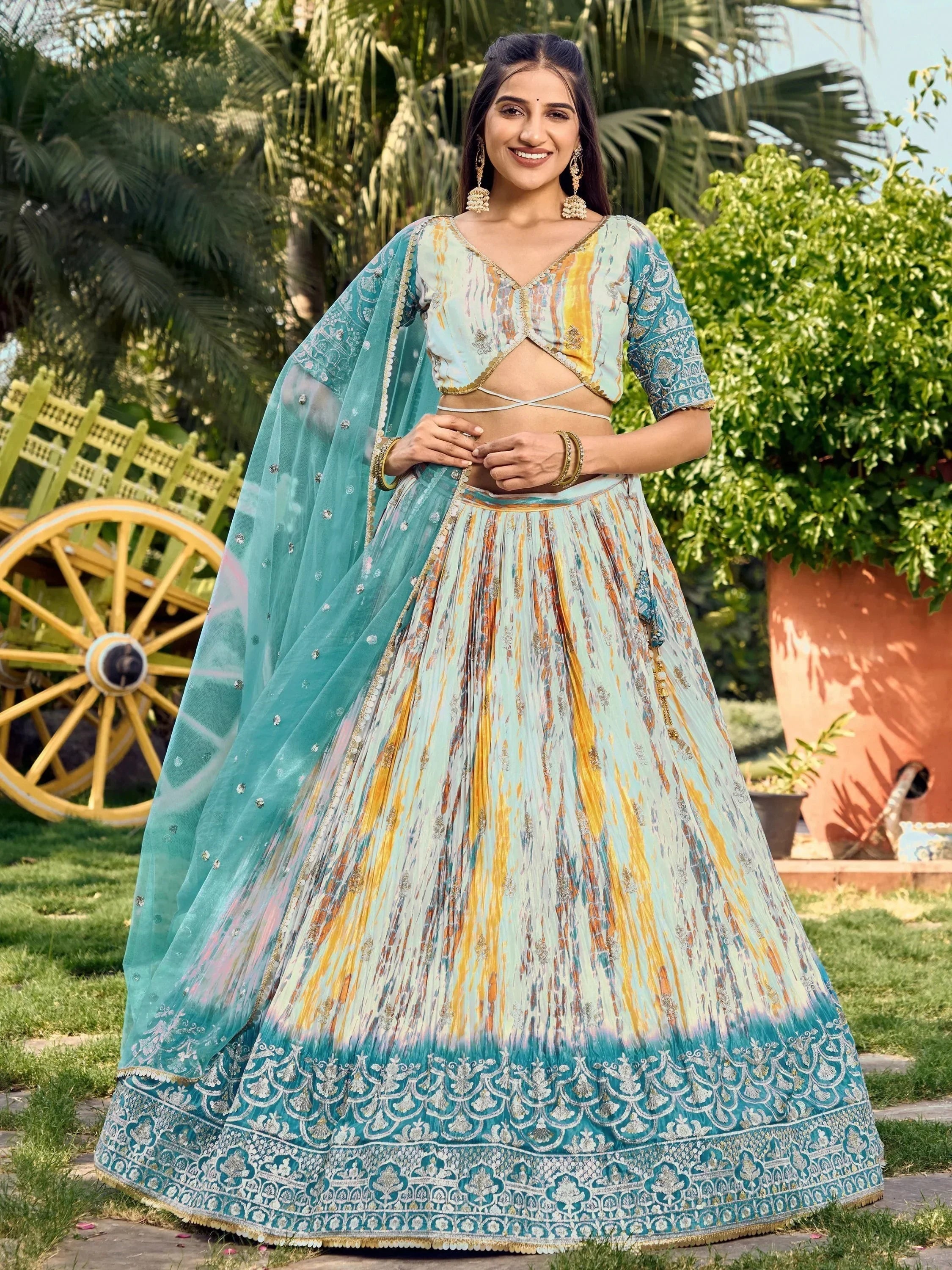 Woman in turquoise and yellow printed lehenga choli with embroidered dupatta, perfect for Indian ethnic occasions