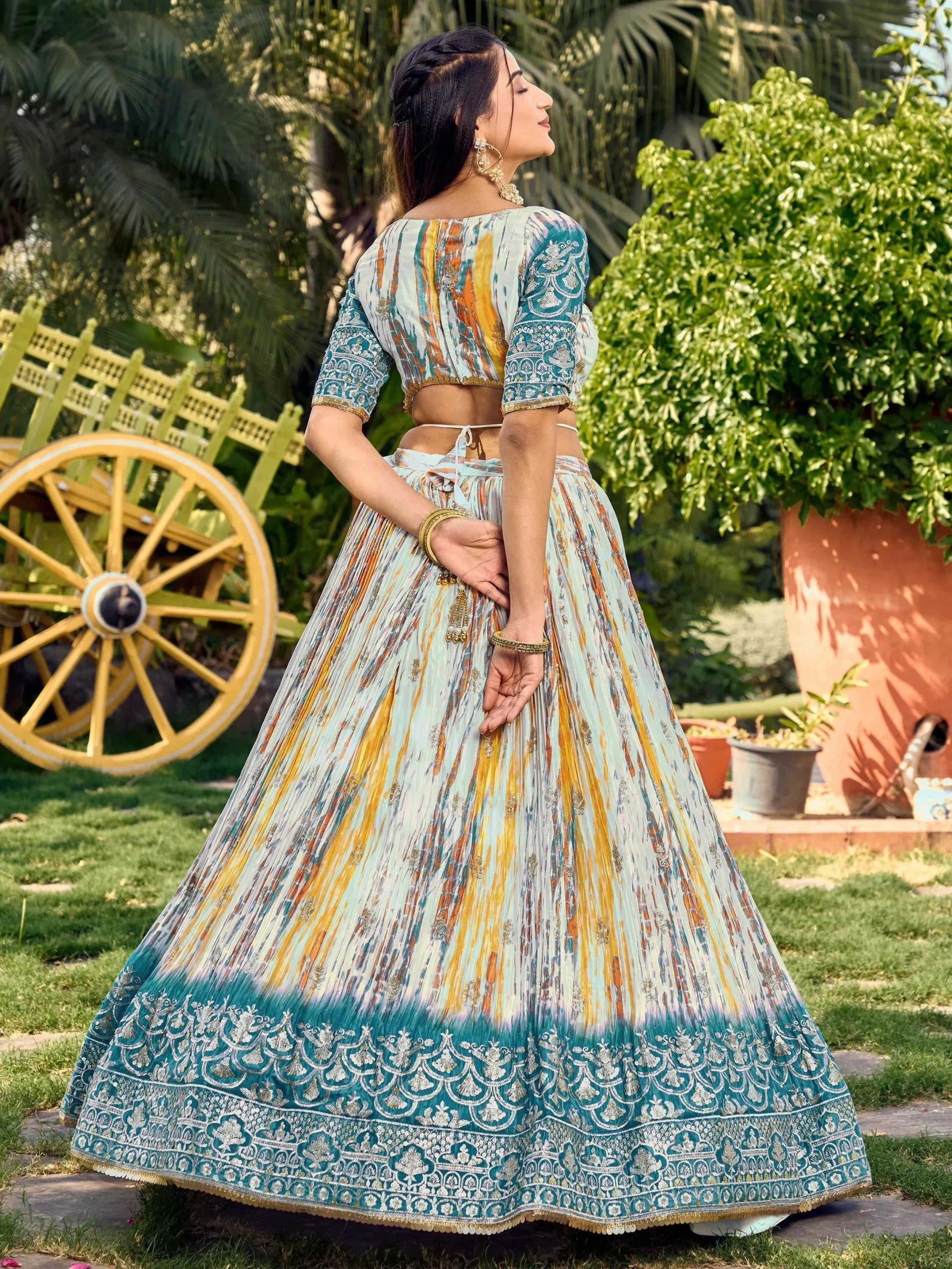 Woman in colorful printed lehenga choli with embroidery, garden setting